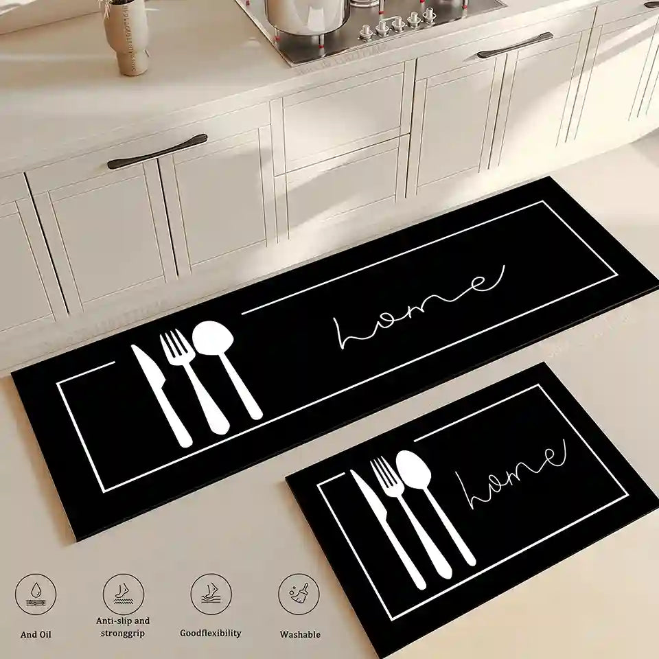Black kitchen mats with white cutlery and 'home' text on a light wooden floor.