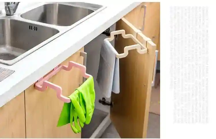 Cabinet door with a pink and green hanging organizer inside a kitchen.