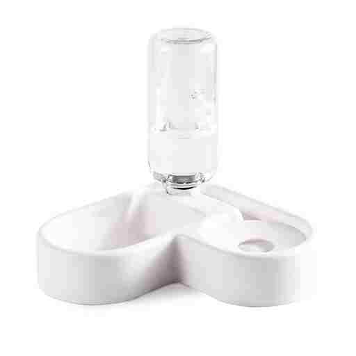 Clear glass bottle on a white ceramic stand with a white background