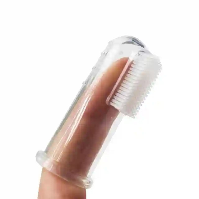 Clear nail brush held by a finger on a white background