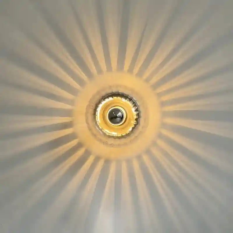 Close-up of a ceiling light fixture with a sunburst pattern