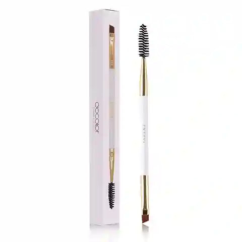 Eyebrow brush with black bristles and gold accents in a white box on a white background