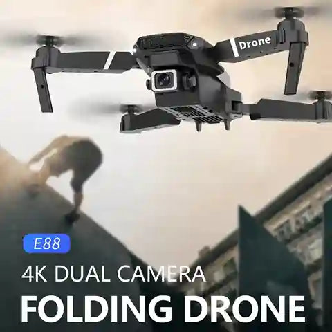 Folding drone with 4K dual camera in flight, with a blurred background of people and buildings.