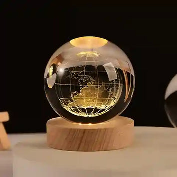 Glass globe with world map on a wooden base against a dark background