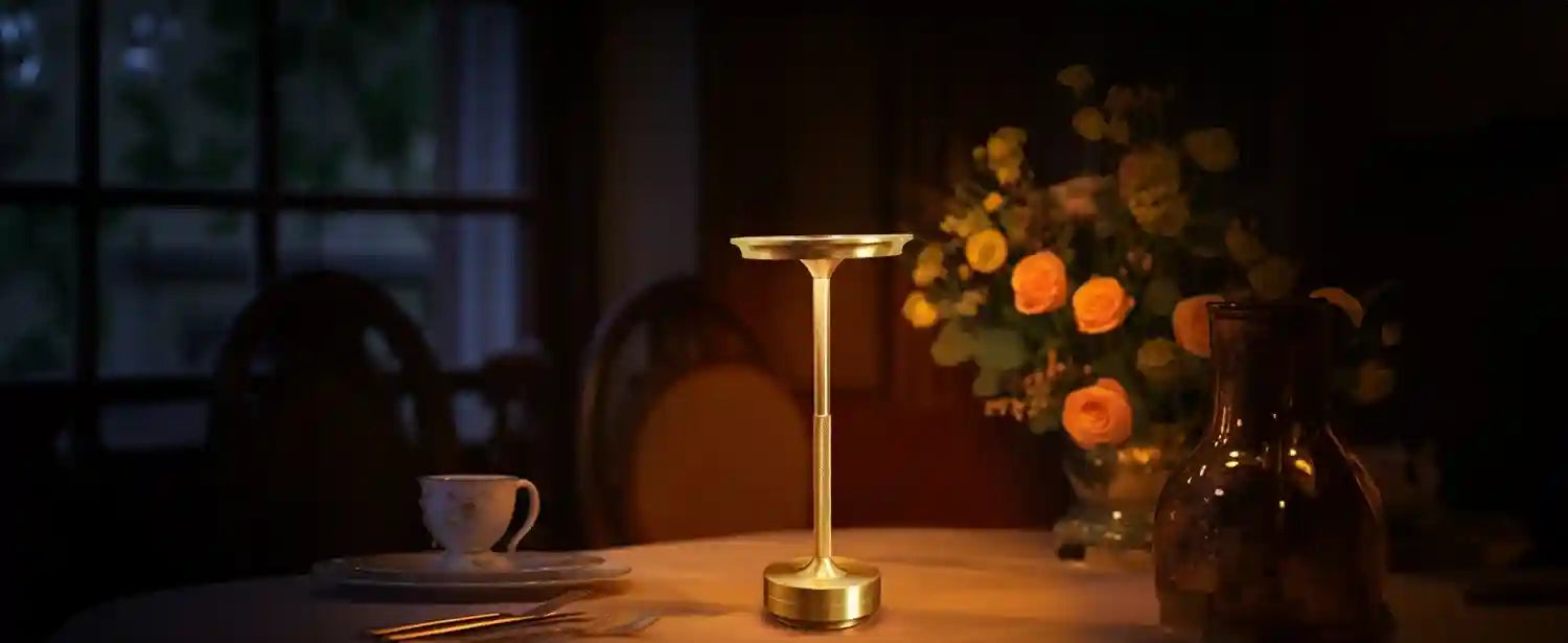 Gold candlestick on a table with a cup and flowers in the background