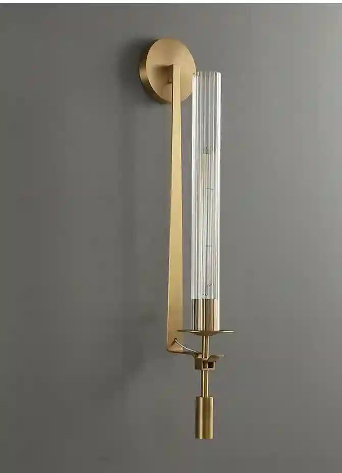 Gold wall sconce with clear glass on a gray background