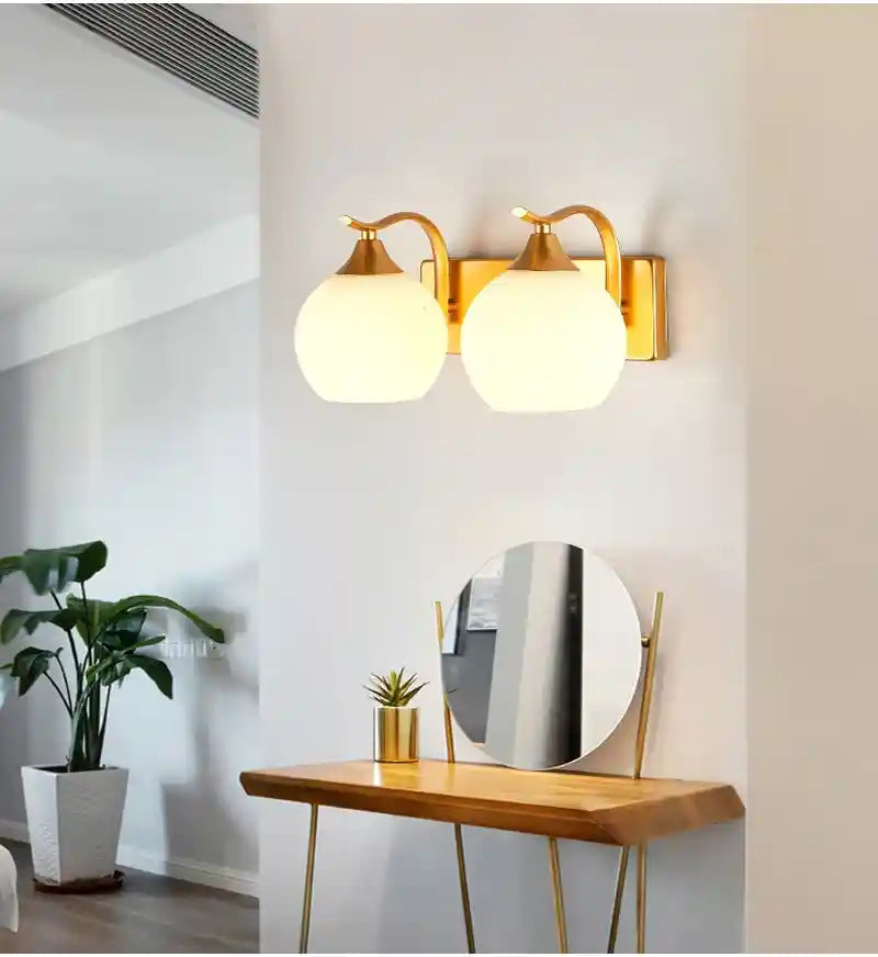 Gold wall sconces with glass shades in a modern interior setting.