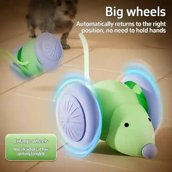 Green and purple toy mouse with wheels on a tiled floor, cat watching.
