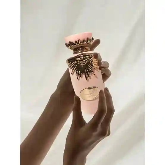 Hand holding a decorative object with intricate design against a plain background