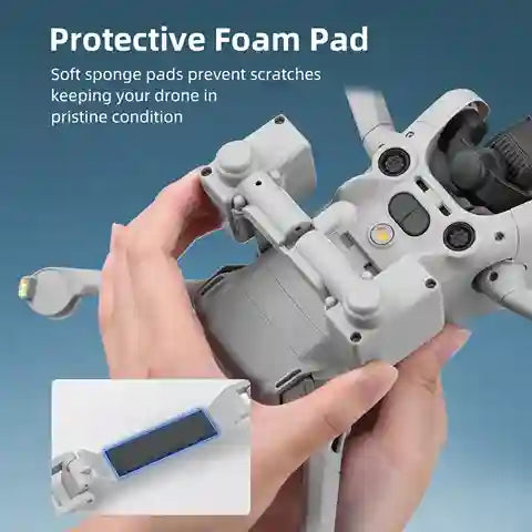 Hand holding a drone with protective foam pad feature on a blue background