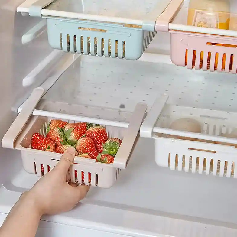 Hand reaching for a container of strawberries in a refrigerator with other storage baskets.