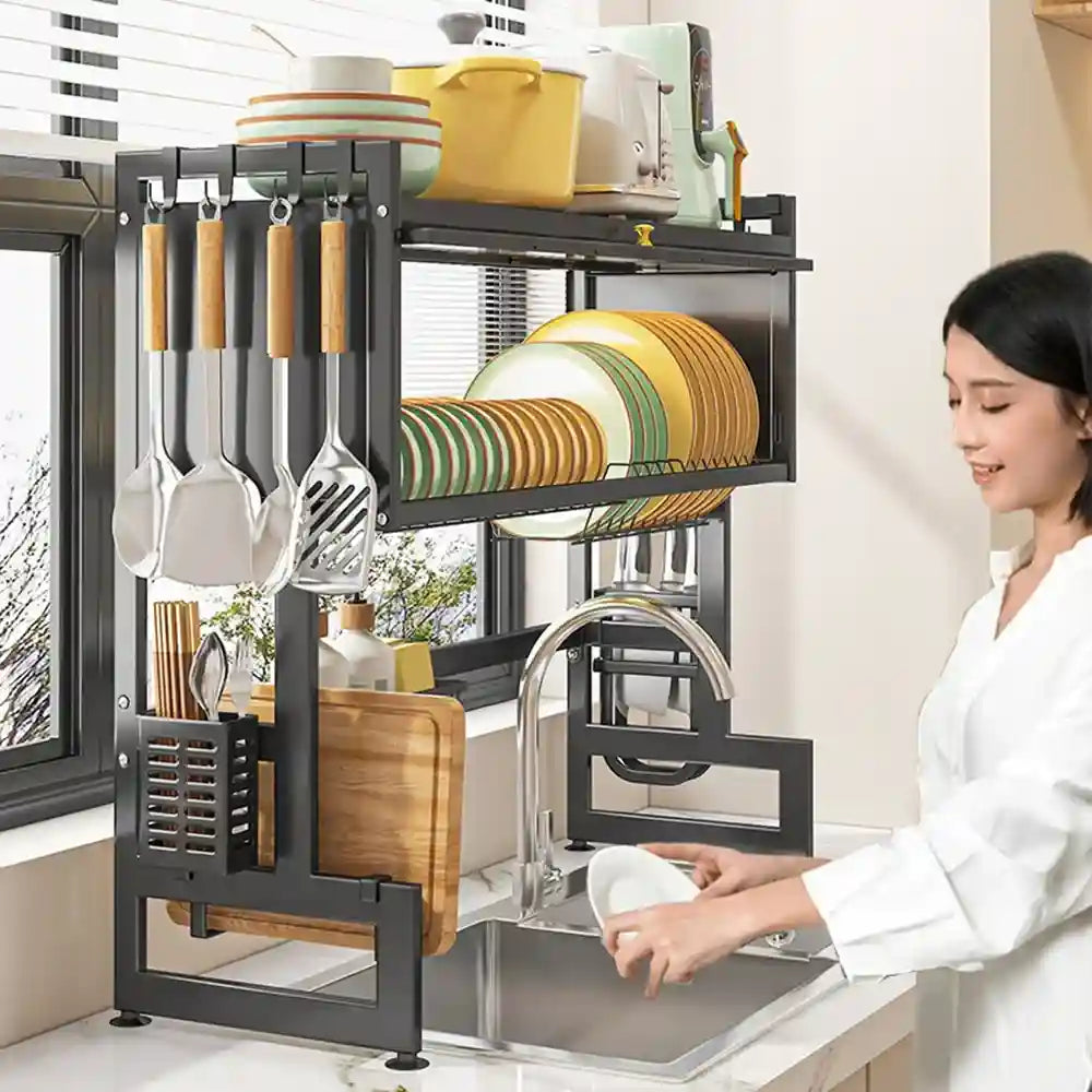 Kitchen utensil rack with plates and utensils next to a person washing dishes.