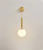 Modern pendant light with gold fixture and white glass shade on a plain background