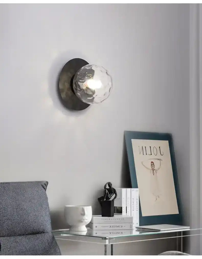 Modern wall sconce with glass shade in a living room setting.