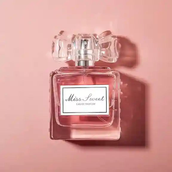 Perfume bottle labeled 'Miss Sweet' on a pink background