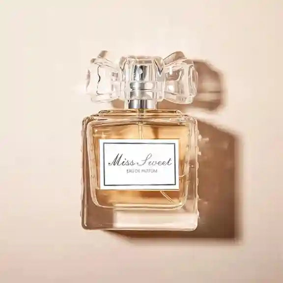 Perfume bottle labeled 'Miss Sweet' on a beige background