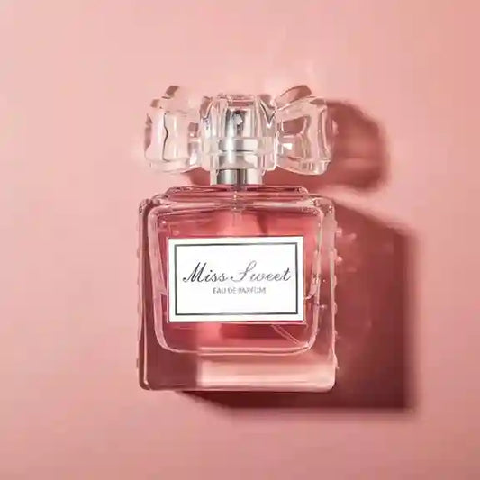 Perfume bottle labeled 'Miss Sweet' on a pink background