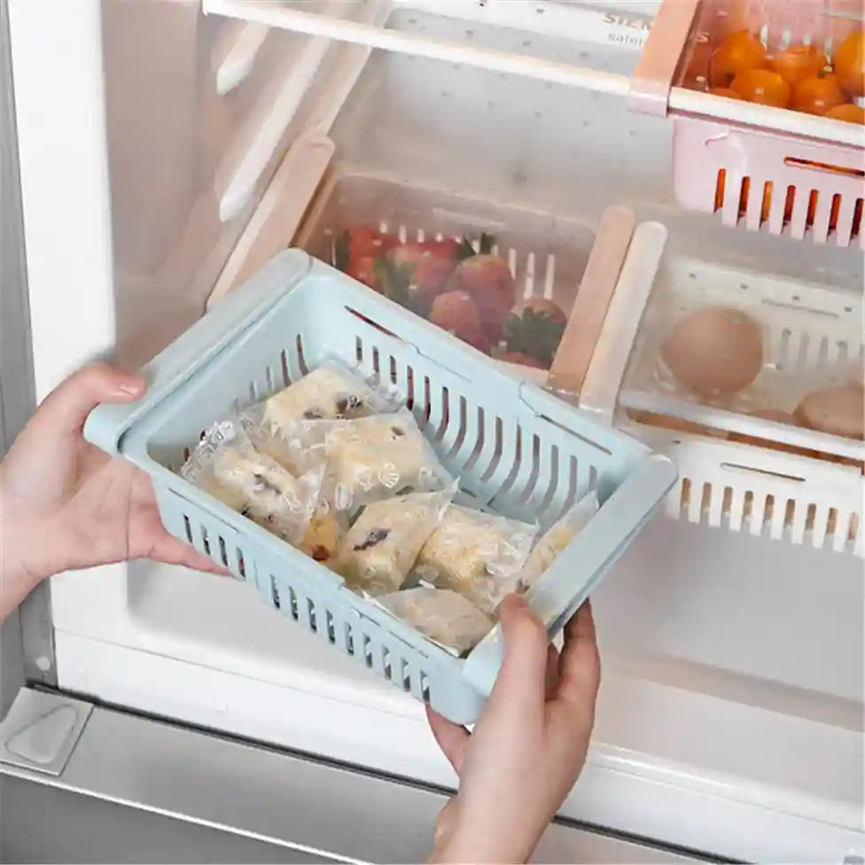 Person holding a blue plastic basket with food items in front of an open refrigerator.