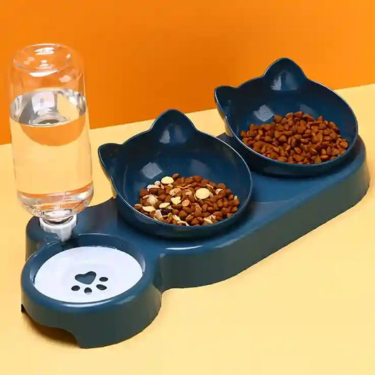 Pet feeding station with two bowls and a glass of water on a yellow surface.