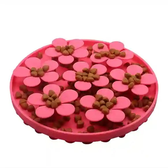 Pink flower-shaped pet feeder with brown treats on a white background