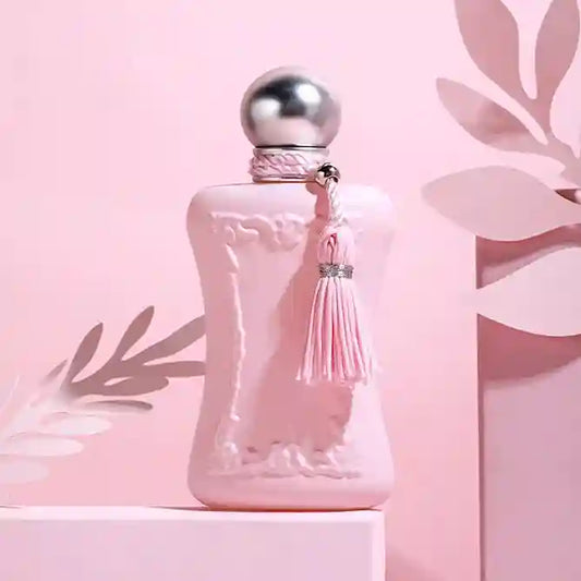 Pink perfume bottle with silver cap and tassel on a pink background