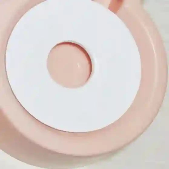 Close-up of a pink and white circular object with a central raised area.