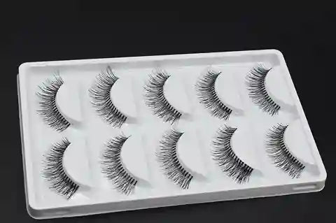 Set of false eyelashes in a white tray on a black background