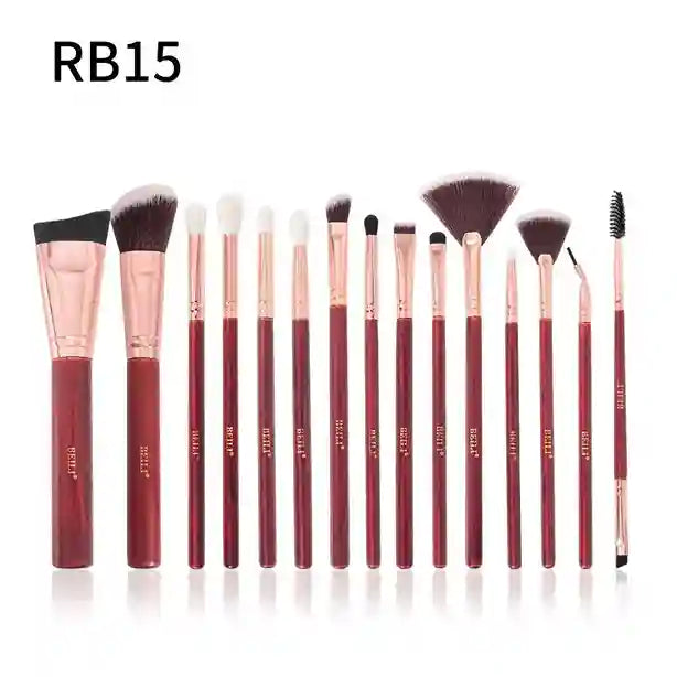 Set of makeup brushes with red and rose gold handles on a white background