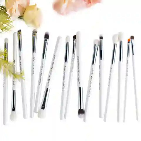 Set of makeup brushes with white handles on a light background