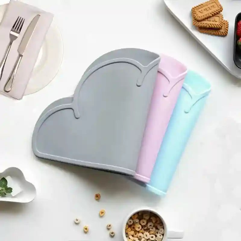 Set of three colorful cutting boards on a white surface with a plate, fork, knife, and cookies in the background.