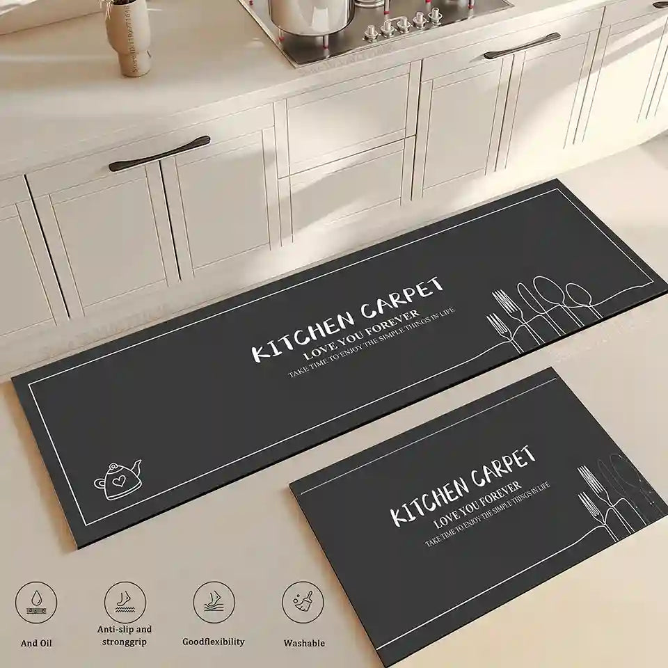 Two black kitchen mats with white text and graphics on a light wooden floor.