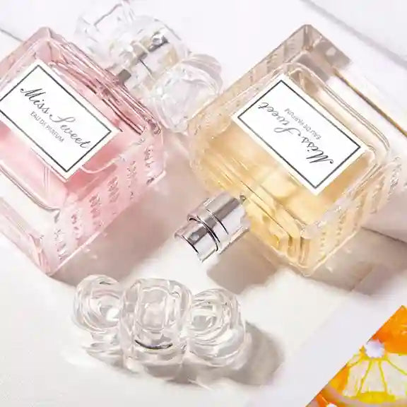 Two perfume bottles labeled 'Miss L'oreal' with rose-shaped caps on a light background.