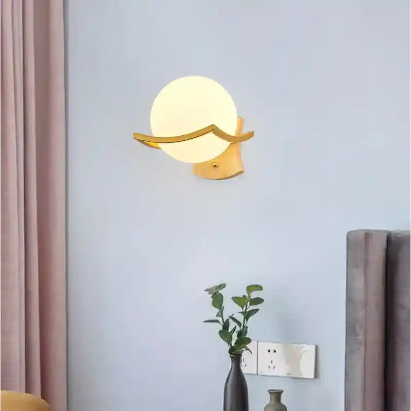 Wall-mounted lamp with a round bulb on a light blue wall.