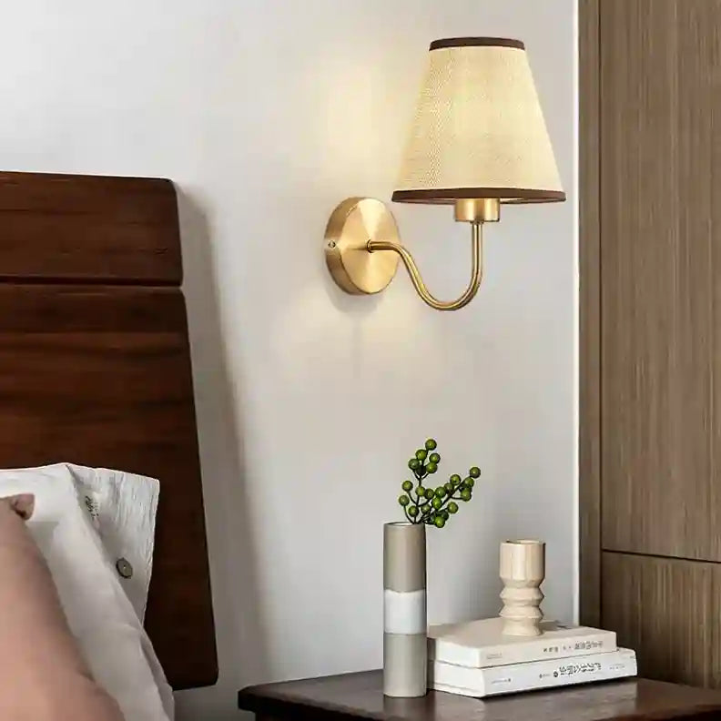 Wall-mounted lamp with a soft glow in a bedroom setting.
