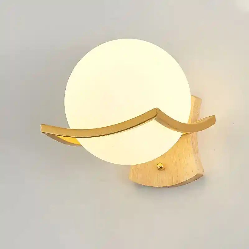 Wall-mounted lamp with a spherical design and gold fixture on a plain background