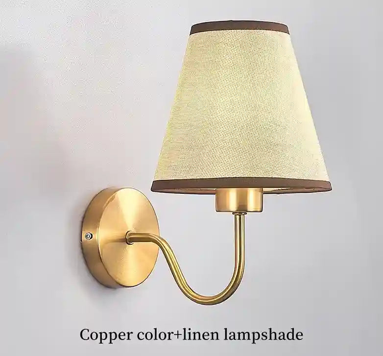 Wall-mounted lamp with linen lampshade and brass fixture on a light gray background