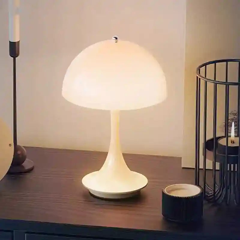 White table lamp on a wooden surface with candles and decorative items.